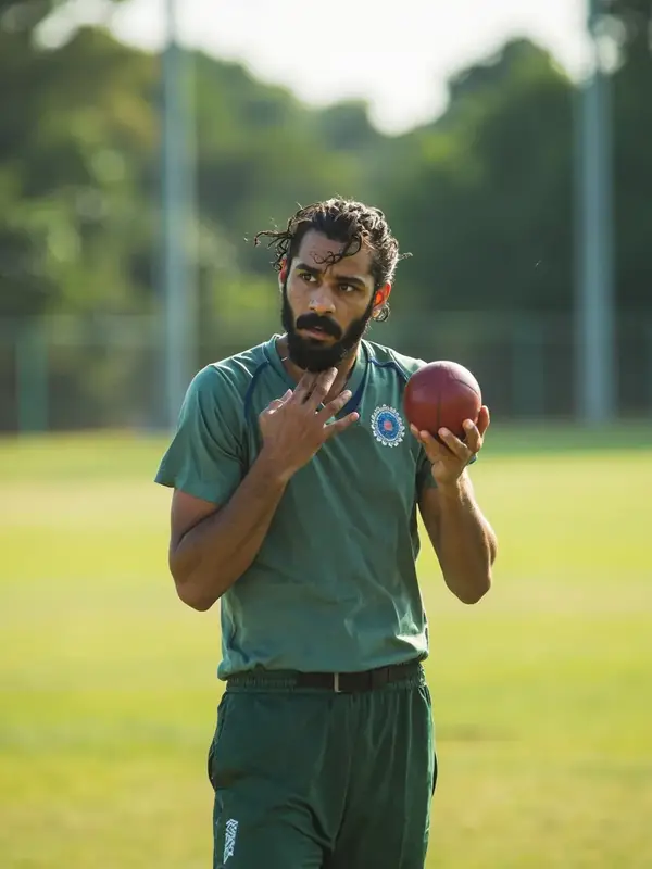 Indian fast bowler in training whites, three-quarter portrait under afternoon sun